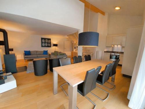 a kitchen and dining room with a table and chairs at Walensee House & Apartments in Unterterzen