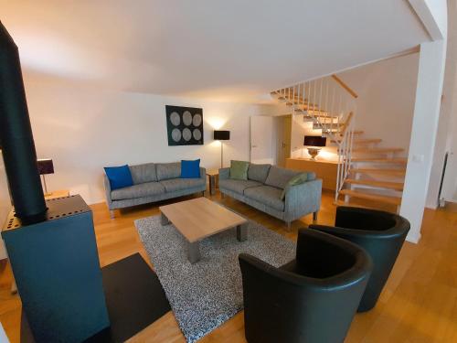 a living room with two couches and a table at Walensee House & Apartments in Unterterzen