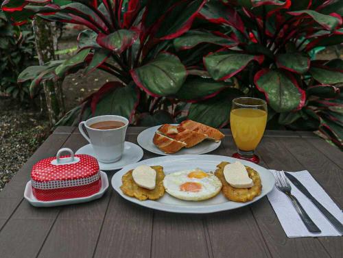 a breakfast of eggs and toast and coffee on a wooden table at Cabaña Villa Sofi in Nuquí