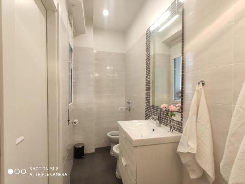 a white bathroom with a sink and a toilet at Luxury House Love in Milan
