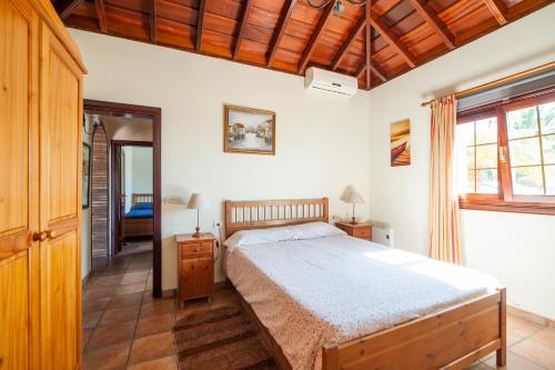 a bedroom with a bed and a wooden ceiling at CASA VAN DE WALLE in Tijarafe