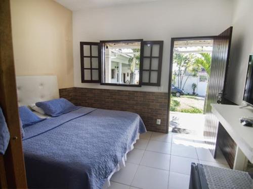 Un dormitorio con una cama azul y una ventana en Pousada Três Pescadores, en Búzios