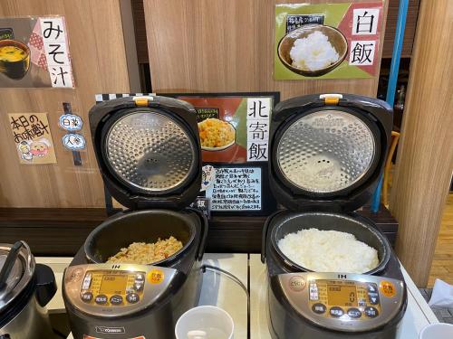 three food machines with rice in them on a counter at Hotel Wing International Tomakomai in Tomakomai