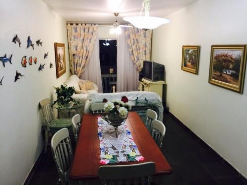 a living room with a table and a couch at Enseada à 450m da praia in Guarujá