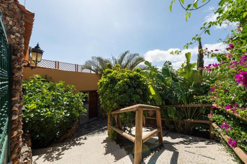 a garden with a wooden bench and flowers at Villa la Atlantida in Ingenio