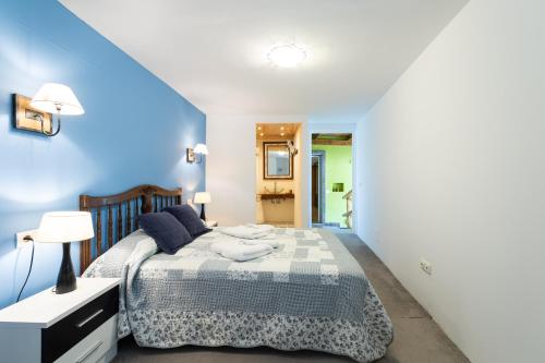 a bedroom with a bed and a blue wall at Villa la Atlantida in Ingenio