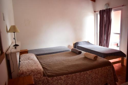 1 dormitorio con 2 camas y ventana en Alojamiento Neuquén en Neuquén