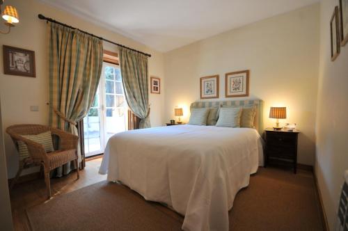 um quarto com uma grande cama branca e uma janela em Casa de Marinhas Country House em Caminha