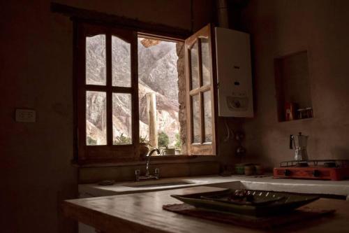 cocina con fregadero y ventana en Ruphay: Cabaña equipada con vista a los cerros en el campo en Maimará