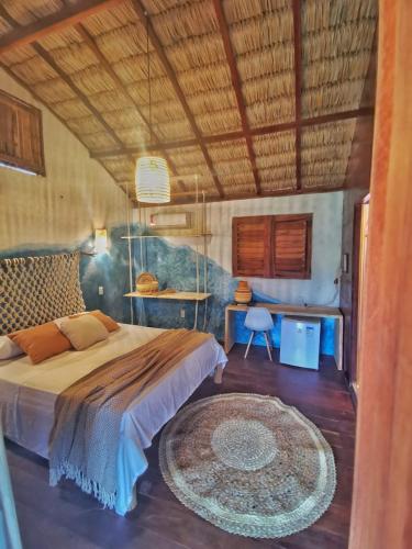 a bedroom with a large bed and a desk at Mangará Pousada in Praia de Moitas