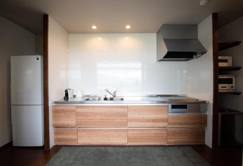 a kitchen with a sink and a refrigerator at Koti Yamanakako next to Hananomiyako Kouen in Yamanakako