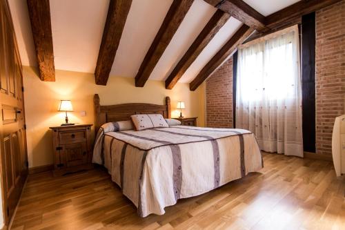 a bedroom with a bed and a large window at Hotel Rural El Paraiso de Gredos in Cuevas del Valle