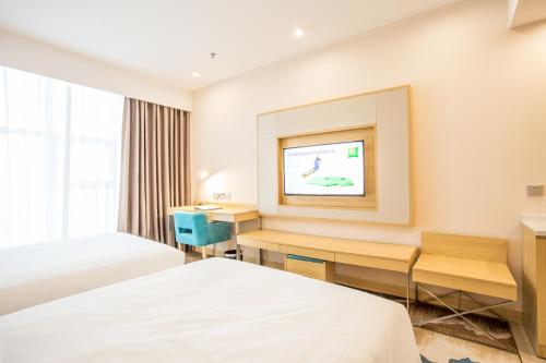 a hotel room with two beds and a tv at ibis Styles Changsha Intl Exhibition Ctr in Huangxing