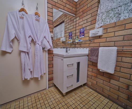 baño con lavabo y pared de ladrillo en City View Motel, en Warwick