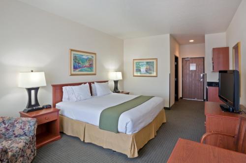 a hotel room with a large bed and a tv at Holiday Inn Express Hotel & Suites Ashland, an IHG Hotel in Ashland