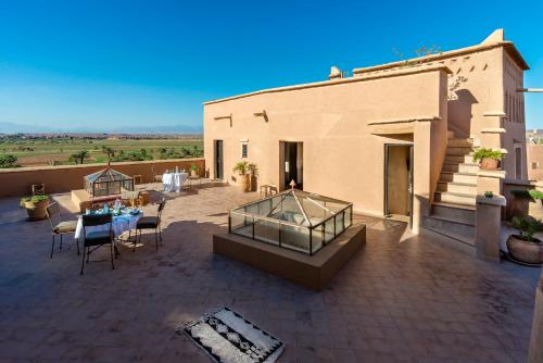 a patio with a table and chairs and a building at Dar Bladi in Ouarzazate