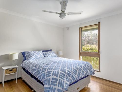 a white bedroom with a bed and a window at Neat And Sweet Blairgowrie Retreat in Blairgowrie