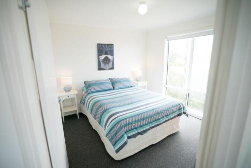 a white bedroom with a bed and a window at SeaWatch-Sea Views in Middleton