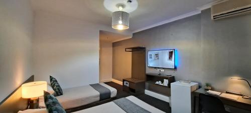 a hotel room with two beds and a television at Criterion Hotel Perth in Perth