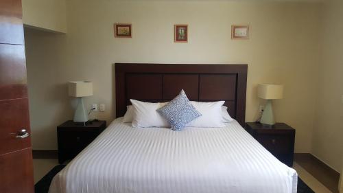 a bedroom with a large bed with pillows and two lamps at Hotel Mirante Tlaxcala in Tlaxcala de Xicohténcatl