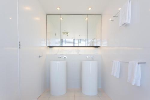 a white bathroom with two sinks and a mirror at Oracle Resort Broadbeach - gclr in Gold Coast