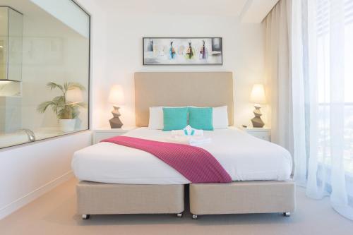 a bedroom with a large white bed in a room at Oracle Resort Broadbeach - gclr in Gold Coast