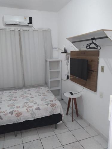 a bedroom with a bed and a tv on a wall at Flatstom in Parnaíba