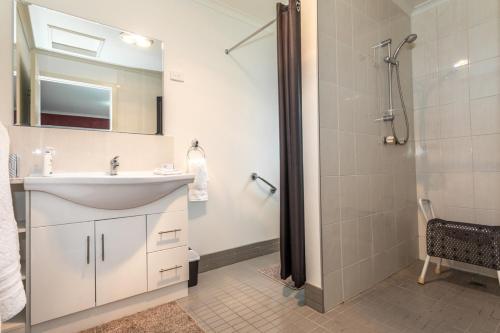 a white bathroom with a sink and a shower at Altona Garden Retreat in Spreyton