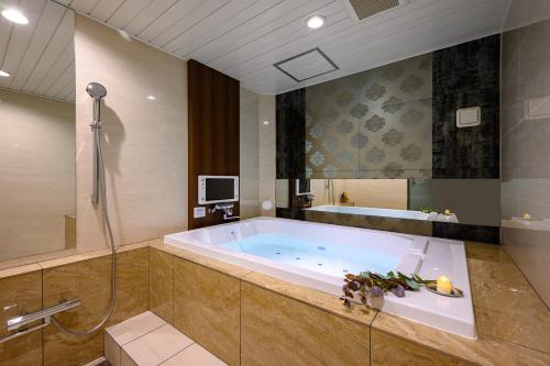 y baño grande con bañera y ducha. en ホテル シードット 横浜 ドゥエ en Yokohama