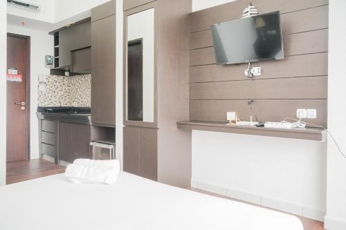 ein Schlafzimmer mit einem TV an der Wand in der Unterkunft Exclusive Studio Room at Casa De Parco Apartment By Travelio in Samporo