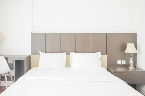 ein Schlafzimmer mit einem großen Bett und weißen Kissen in der Unterkunft Exclusive Studio Room at Casa De Parco Apartment By Travelio in Samporo