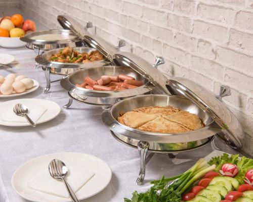 タシュケントにあるHuzur Hotel Tashkentのテーブルの上にたくさんの料理が並んだビュッフェ
