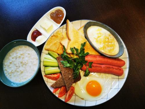 un plato de desayuno con huevos, pan y verduras en Royal Petrol Hotel, en Taldykorgan