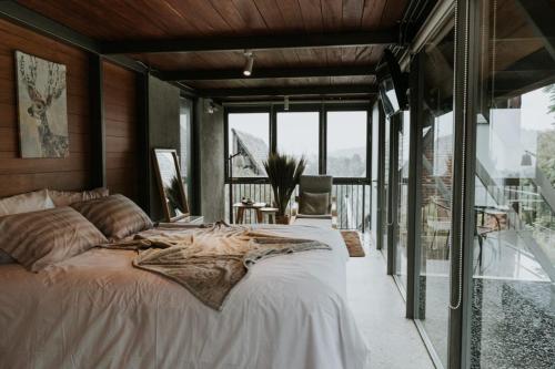een slaapkamer met een groot bed en een groot raam bij villa tibra in Lembang