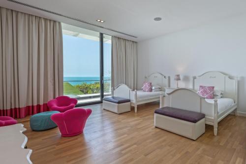 a bedroom with white furniture and a large window at Paradise Nurai Villa - 6 Bedrooms in Abu Dhabi