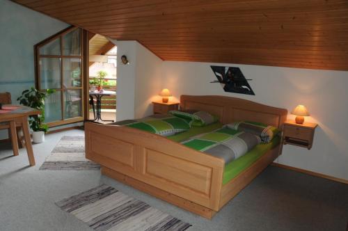 a bedroom with a large wooden bed with two lamps at Ferienwohnung Lanzinger inkl. Chiemgaukarte in Ruhpolding