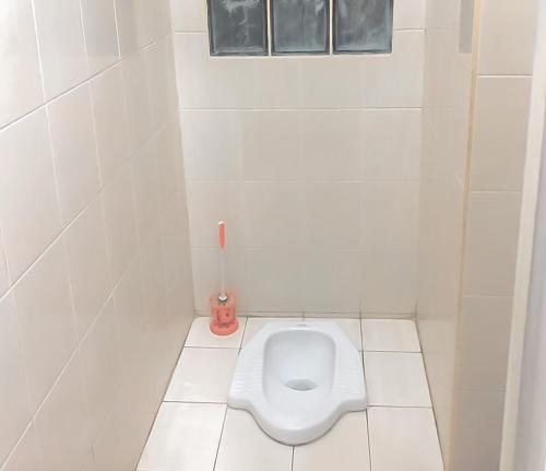 uma casa de banho branca com um WC numa cabina em Homestay Levida Mitra RedDoorz em Samarinda