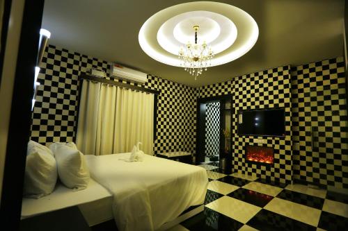 a bedroom with a bed and a chandelier at Mehar Inn Hotel in Kāraikkudi