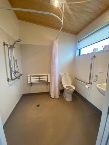 a bathroom with a toilet and a sink and a window at Country Retreats on Ranzau 1 in Nelson