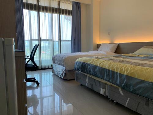 two beds in a hotel room with large windows at Emerald diamond Building 1 in Zhunan