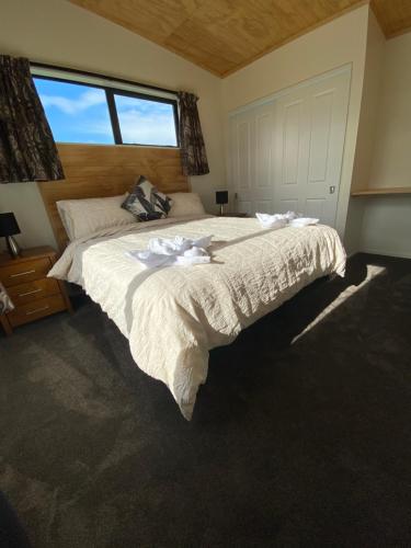 a bedroom with a large bed with a large window at Country Retreats on Ranzau 3 in Nelson