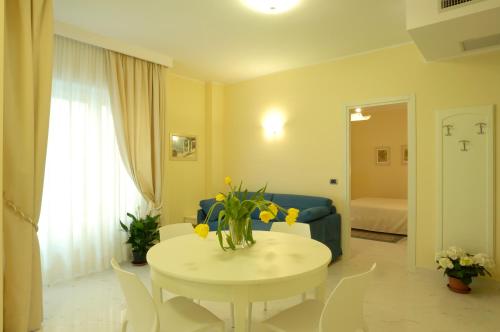 salon ze stołem z żółtymi kwiatami w obiekcie Residence Atlantic w Alassio