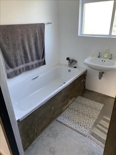 a bathroom with a bath tub and a sink at Konings Cottage in Gansbaai