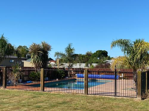 a fence in front of a swimming pool at Country Retreats on Ranzau 3 in Nelson
