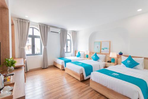 a hotel room with three beds in it at Rivera Tuy Hòa Hotel in Tuy Hoa