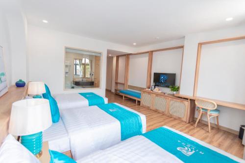 a large room with two beds and a television at Rivera Tuy Hòa Hotel in Tuy Hoa
