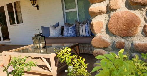 a patio with a bench with pillows and a table at Big Sky Ranch in Colesberg