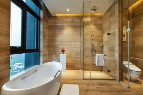 a bathroom with a tub and a glass shower at Holiday Inn Putian Xiuyu, an IHG Hotel in Putian