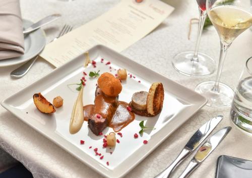 a plate of food on a table with wine glasses at InterContinental Bahrain by IHG in Manama