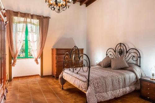 a bedroom with a bed and a chandelier at El Huerto in Firgas